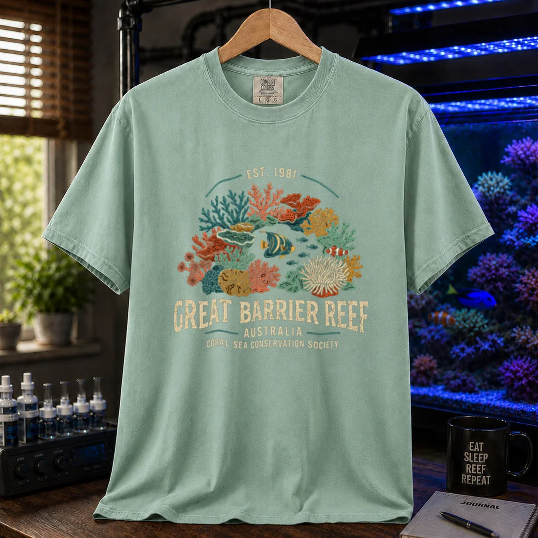 Saltwater aquarium graphic t-shirt featuring detailed vintage illustration of coral reefs and tropical fish with text reading Great Barrier Reef Australia Coral Sea Conservation Society Est. 1981, green crew neck tee