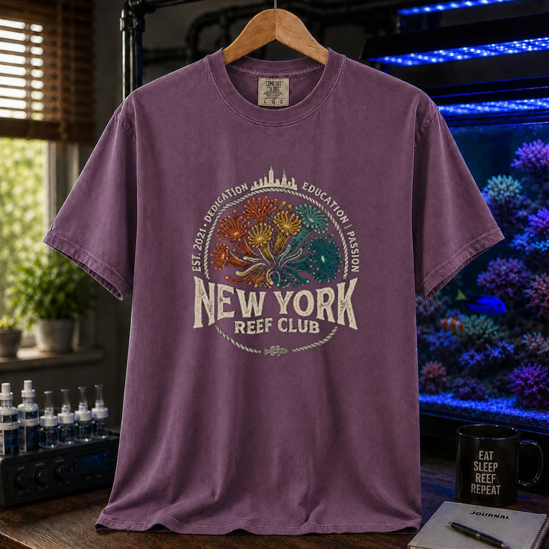 Saltwater aquarium graphic t-shirt featuring vintage emblem design with New York skyline, coral polyps, and text reading New York Reef Club Est. 2021 Dedication Education Passion, purple crew neck tee