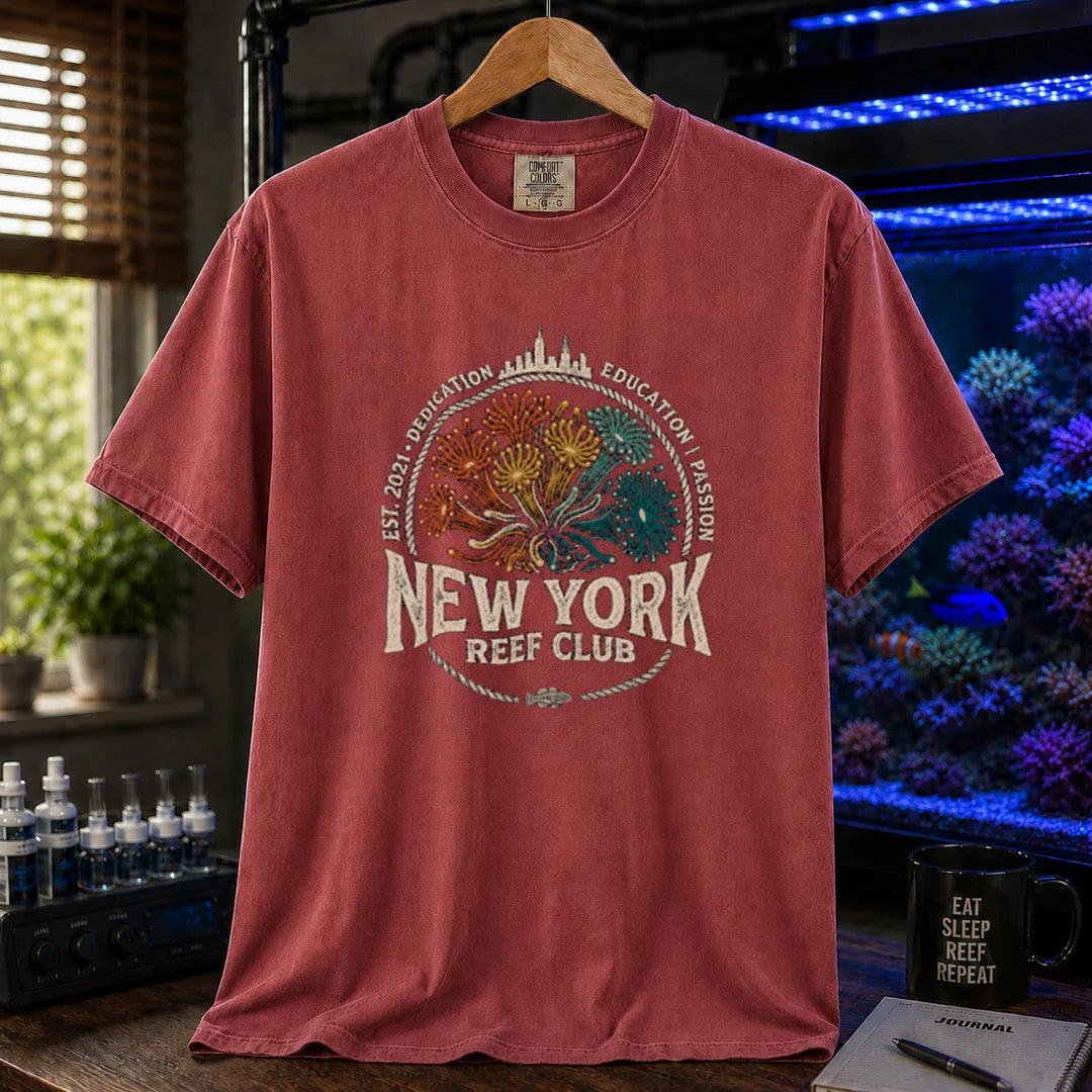 Saltwater aquarium graphic t-shirt featuring vintage emblem design with New York skyline, coral polyps, and text reading New York Reef Club Est. 2021 Dedication Education Passion, maroon, red crew neck tee