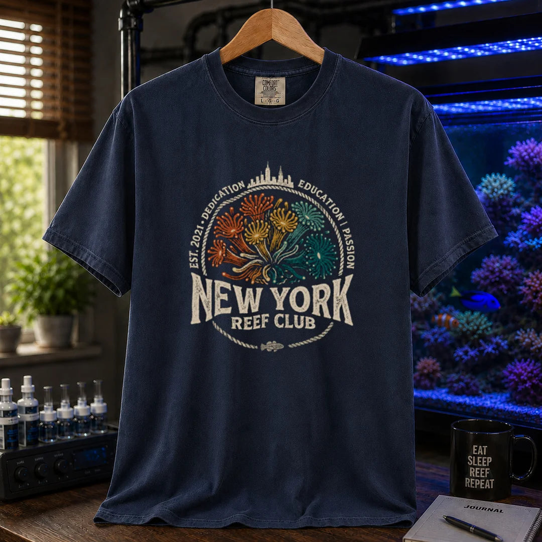 Saltwater aquarium graphic t-shirt featuring vintage emblem design with New York skyline, coral polyps, and text reading New York Reef Club Est. 2021 Dedication Education Passion, navy crew neck tee