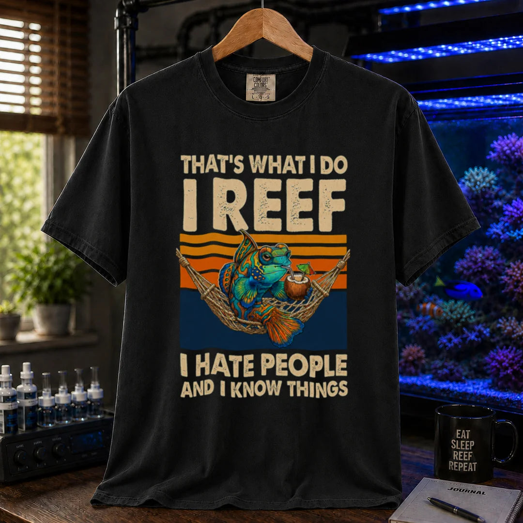 Saltwater aquarium graphic t-shirt featuring a mandarin goby in a hammock with a drink against a retro sunset and text reading That's What I Do I Reef I Hate People And I Know Things, black crew neck tee