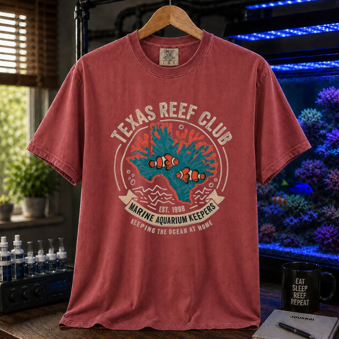 Saltwater aquarium graphic t-shirt featuring a vintage emblem with coral shaped like Texas, clownfish, and text reading Texas Reef Club Marine Aquarium Keepers Est. 1998, maroon, red crew neck tee