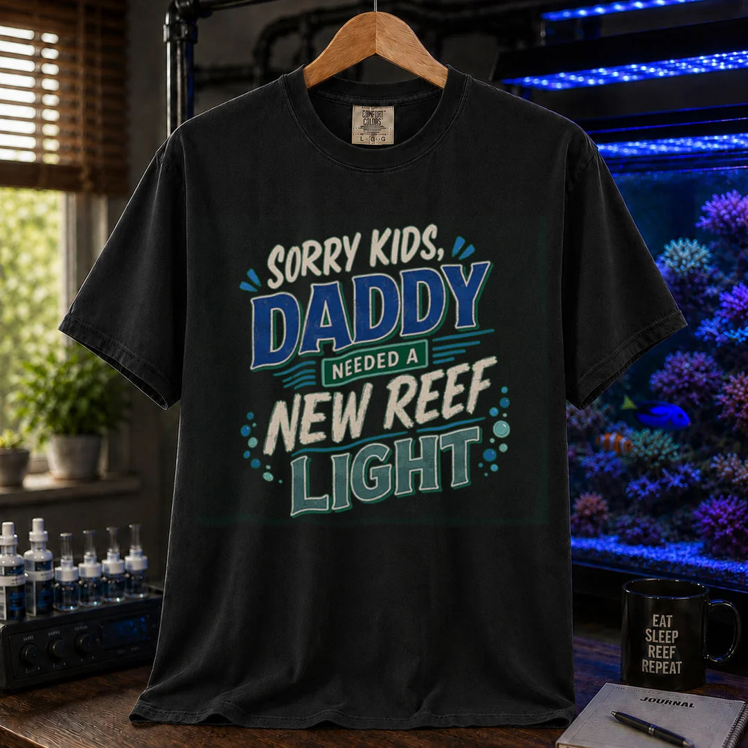 Saltwater aquarium graphic t-shirt featuring multi-color distressed typography reading Sorry Kids, Daddy Needed A New Reef Light with bubble accents, black crew neck tee