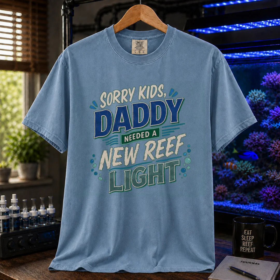 Saltwater aquarium graphic t-shirt featuring multi-color distressed typography reading Sorry Kids, Daddy Needed A New Reef Light with bubble accents, blue crew neck tee