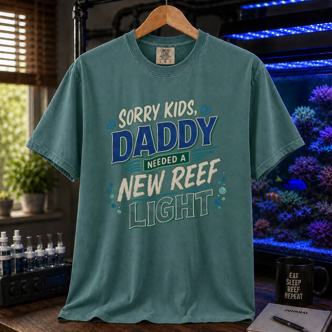 Saltwater aquarium graphic t-shirt featuring multi-color distressed typography reading Sorry Kids, Daddy Needed A New Reef Light with bubble accents, green crew neck tee