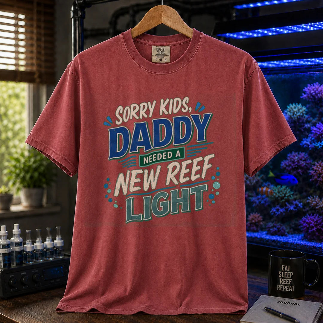 Saltwater aquarium graphic t-shirt featuring multi-color distressed typography reading Sorry Kids, Daddy Needed A New Reef Light with bubble accents, maroon, red crew neck tee