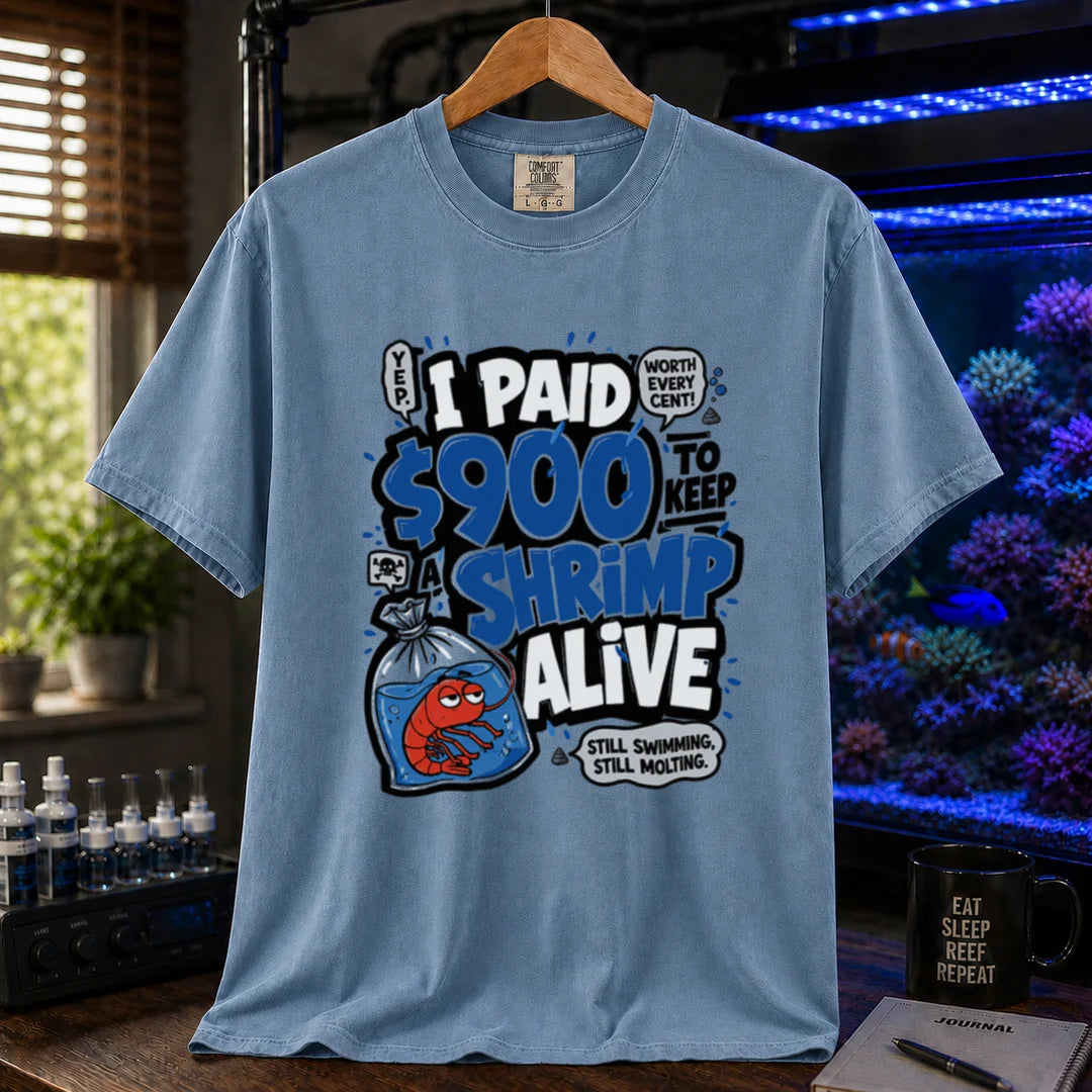 Saltwater aquarium graphic t-shirt featuring comic typography and a cartoon shrimp in a bag with text reading I Paid $900 To Keep A Shrimp Alive, blue crew neck tee