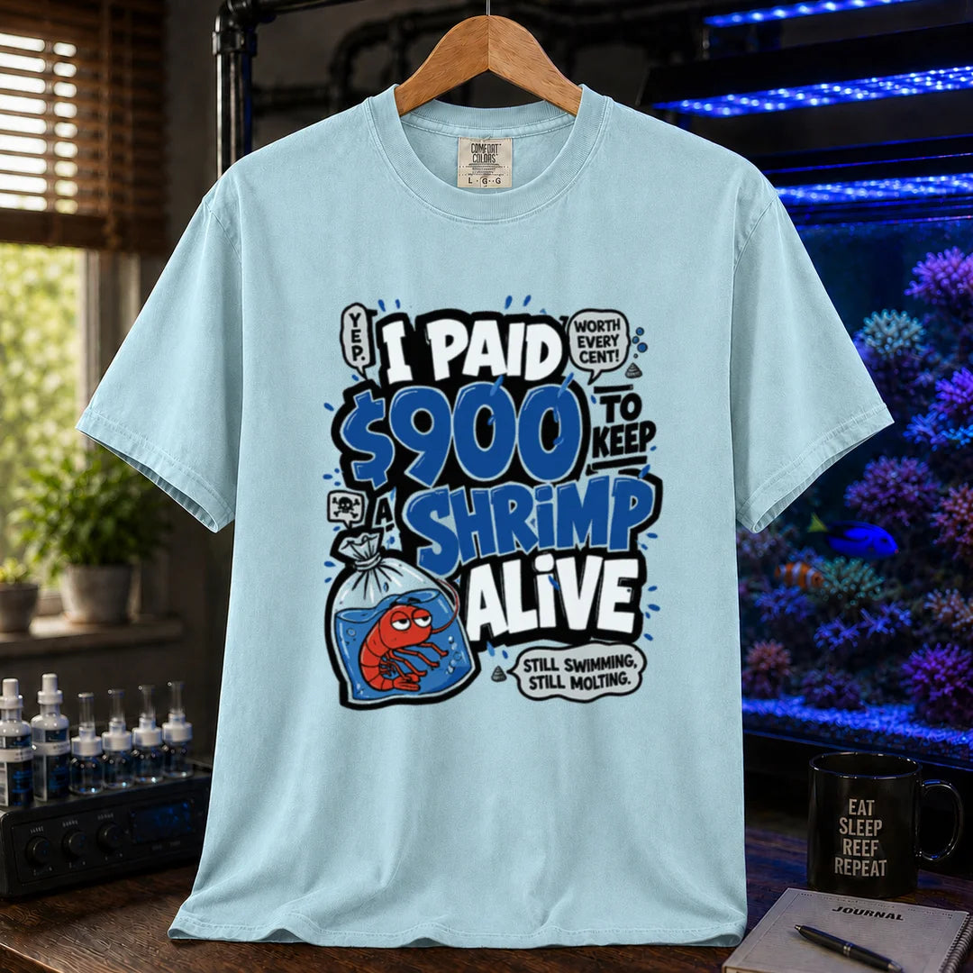 Saltwater aquarium graphic t-shirt featuring comic typography and a cartoon shrimp in a bag with text reading I Paid $900 To Keep A Shrimp Alive, light blue crew neck tee
