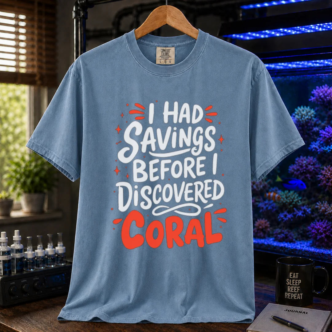 Saltwater aquarium graphic t-shirt featuring playful white and coral typography with sparkle accents reading I Had Savings Before I Discovered Coral, blue crew neck tee