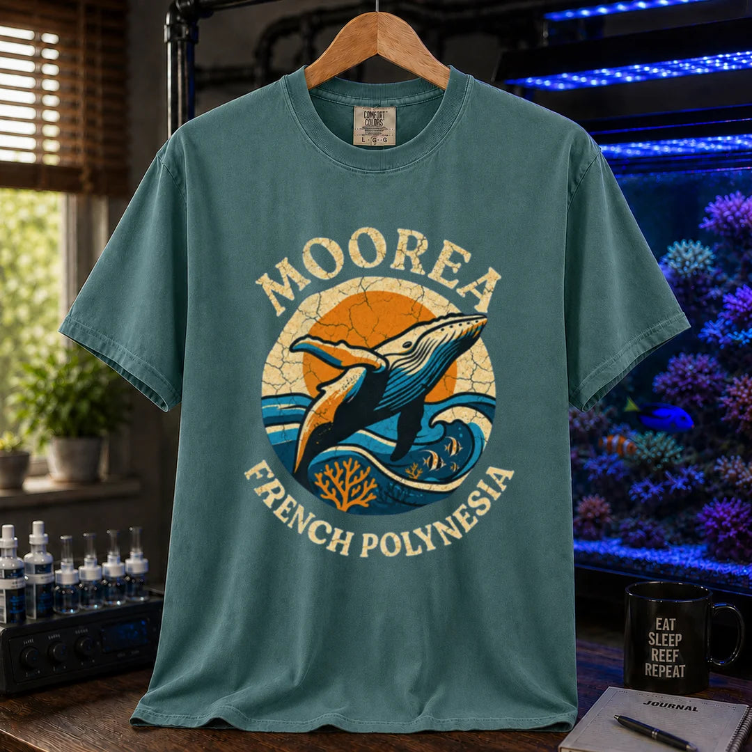 Saltwater aquarium graphic t-shirt featuring a retro circular emblem with a breaching whale and coral, arched text reading Moorea French Polynesia, green crew neck tee
