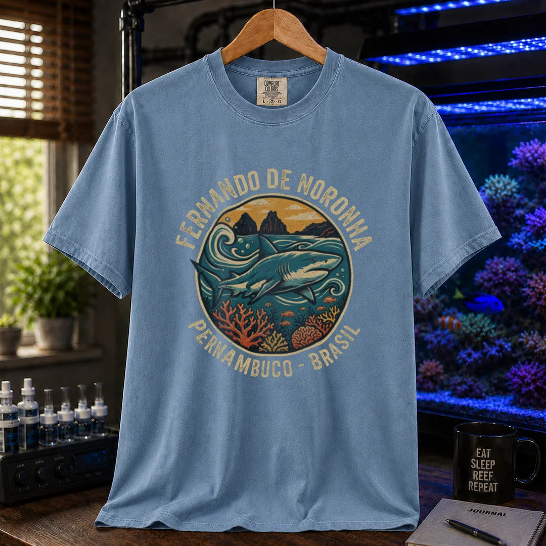 Saltwater aquarium graphic t-shirt featuring a retro circular emblem with a shark and coral, arched text reading Fernando de Noronha Pernambuco Brasil, blue crew neck tee