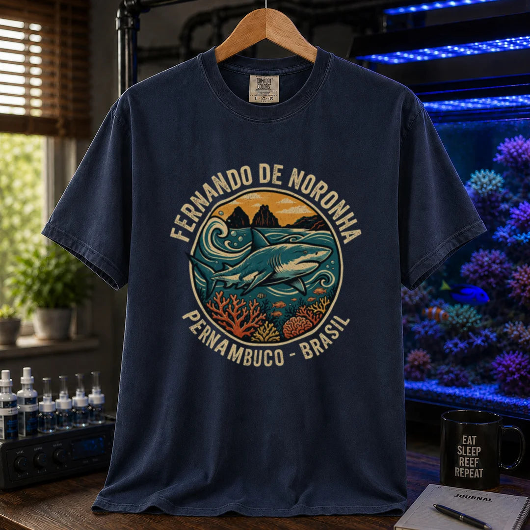 Saltwater aquarium graphic t-shirt featuring a retro circular emblem with a shark and coral, arched text reading Fernando de Noronha Pernambuco Brasil, navy crew neck tee