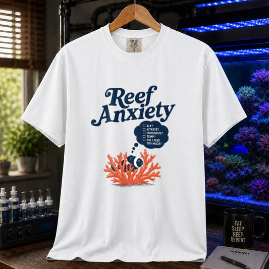 Saltwater aquarium graphic t-shirt featuring blue text reading Reef Anxiety and an illustration of a clownfish in coral with a thought bubble checklist, white crew neck tee