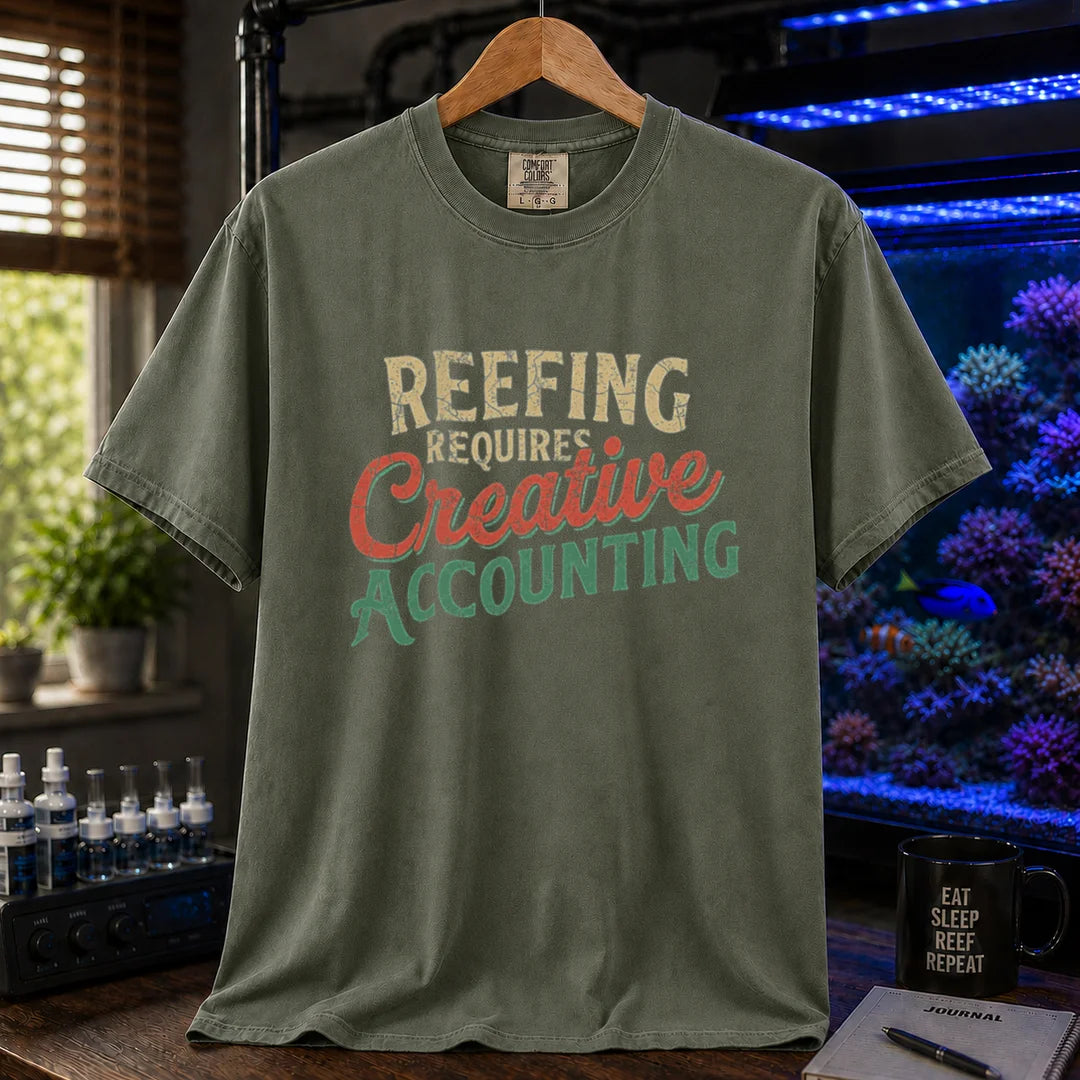 Saltwater aquarium graphic t-shirt featuring distressed retro typography in cream, red, and green reading Reefing Requires Creative Accounting, military green crew neck tee