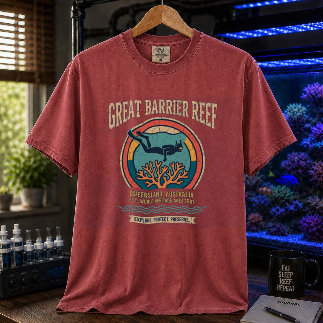 Saltwater aquarium graphic t-shirt featuring a retro circular emblem with a scuba diver and coral, arched text reading Great Barrier Reef Queensland Australia Est World Heritage Area 1981, maroon, red crew neck tee