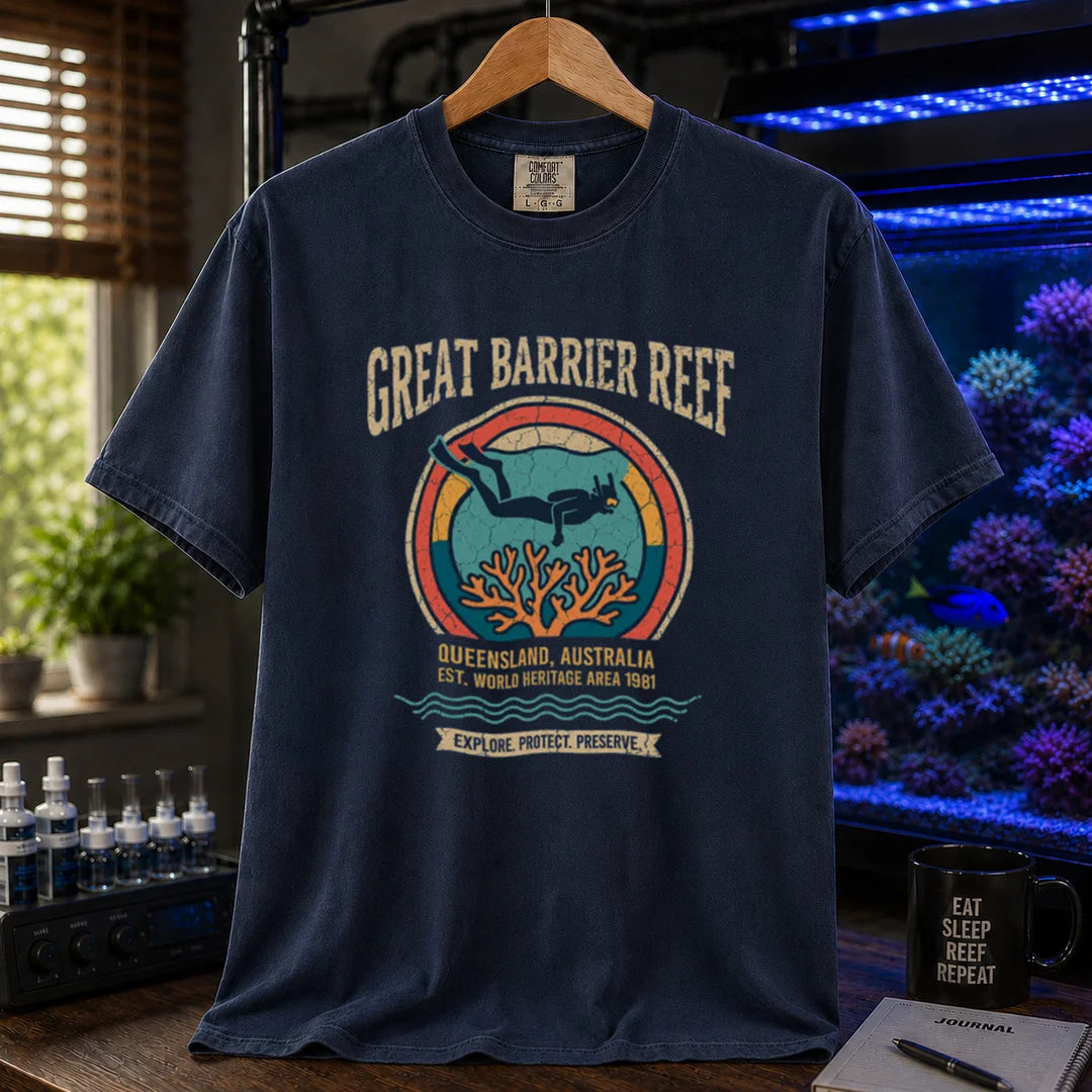 Saltwater aquarium graphic t-shirt featuring a retro circular emblem with a scuba diver and coral, arched text reading Great Barrier Reef Queensland Australia Est World Heritage Area 1981, navy crew neck tee