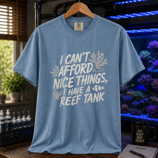 Saltwater aquarium graphic t-shirt featuring distressed white typography reading I Can't Afford Nice Things, I Have A Reef Tank with coral and clownfish illustrations, blue crew neck tee