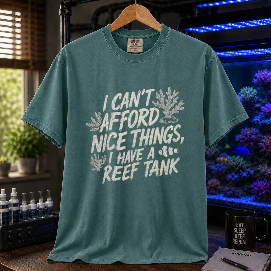Saltwater aquarium graphic t-shirt featuring distressed white typography reading I Can't Afford Nice Things, I Have A Reef Tank with coral and clownfish illustrations, green crew neck tee