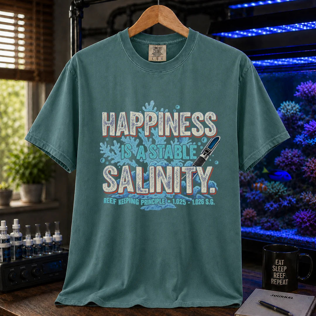 Saltwater aquarium graphic t-shirt featuring distressed retro typography reading Happiness Is A Stable Salinity with coral and refractometer illustrations, green crew neck tee