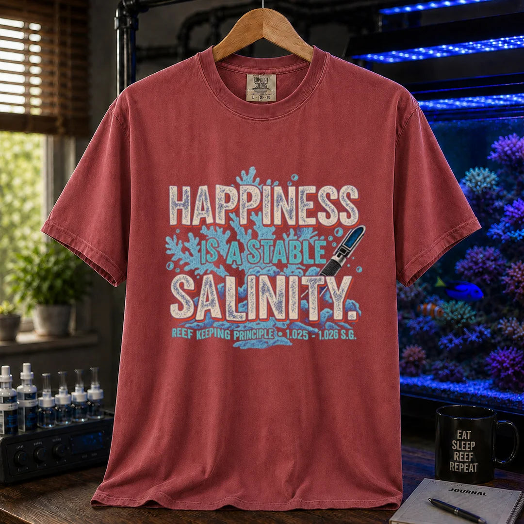 Saltwater aquarium graphic t-shirt featuring distressed retro typography reading Happiness Is A Stable Salinity with coral and refractometer illustrations, maroon, red crew neck tee
