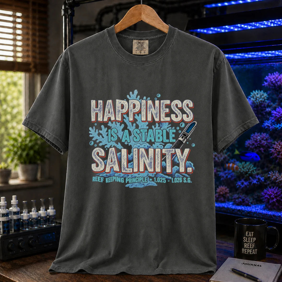 Saltwater aquarium graphic t-shirt featuring distressed retro typography reading Happiness Is A Stable Salinity with coral and refractometer illustrations, dark grey crew neck tee