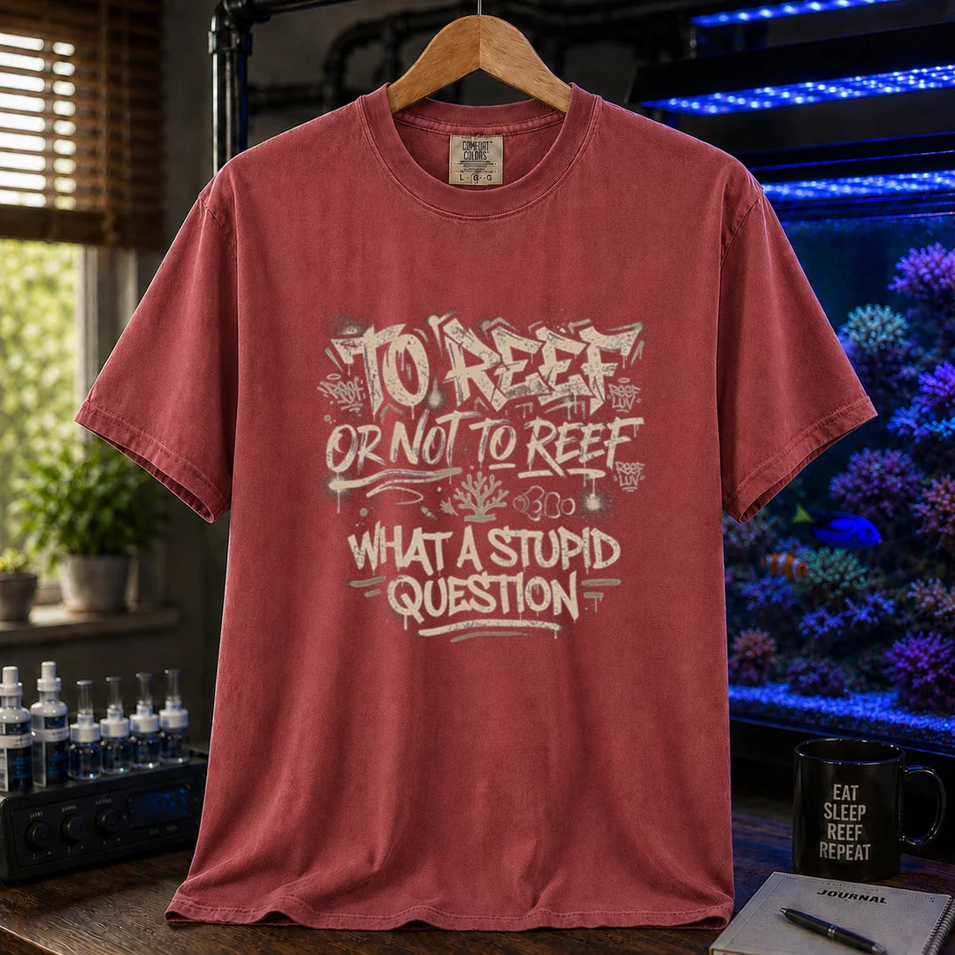 Saltwater aquarium graphic t-shirt featuring distressed white graffiti-style typography reading To Reef Or Not To Reef What A Stupid Question with coral and clownfish icons, maroon, red crew neck tee