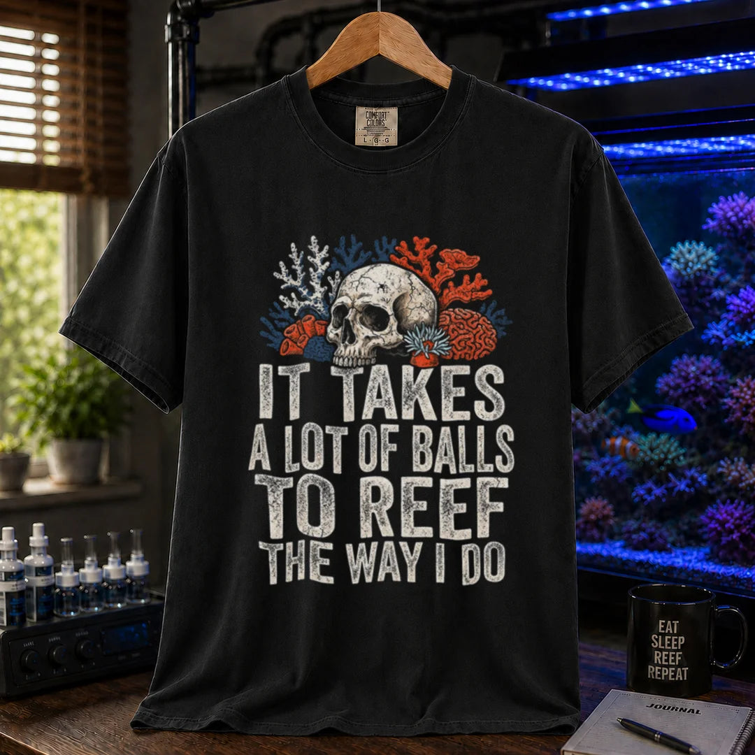 Saltwater aquarium graphic t-shirt featuring distressed white typography reading It Takes A Lot Of Balls To Reef The Way I Do with an illustration of a skull and coral formations, black crew neck tee