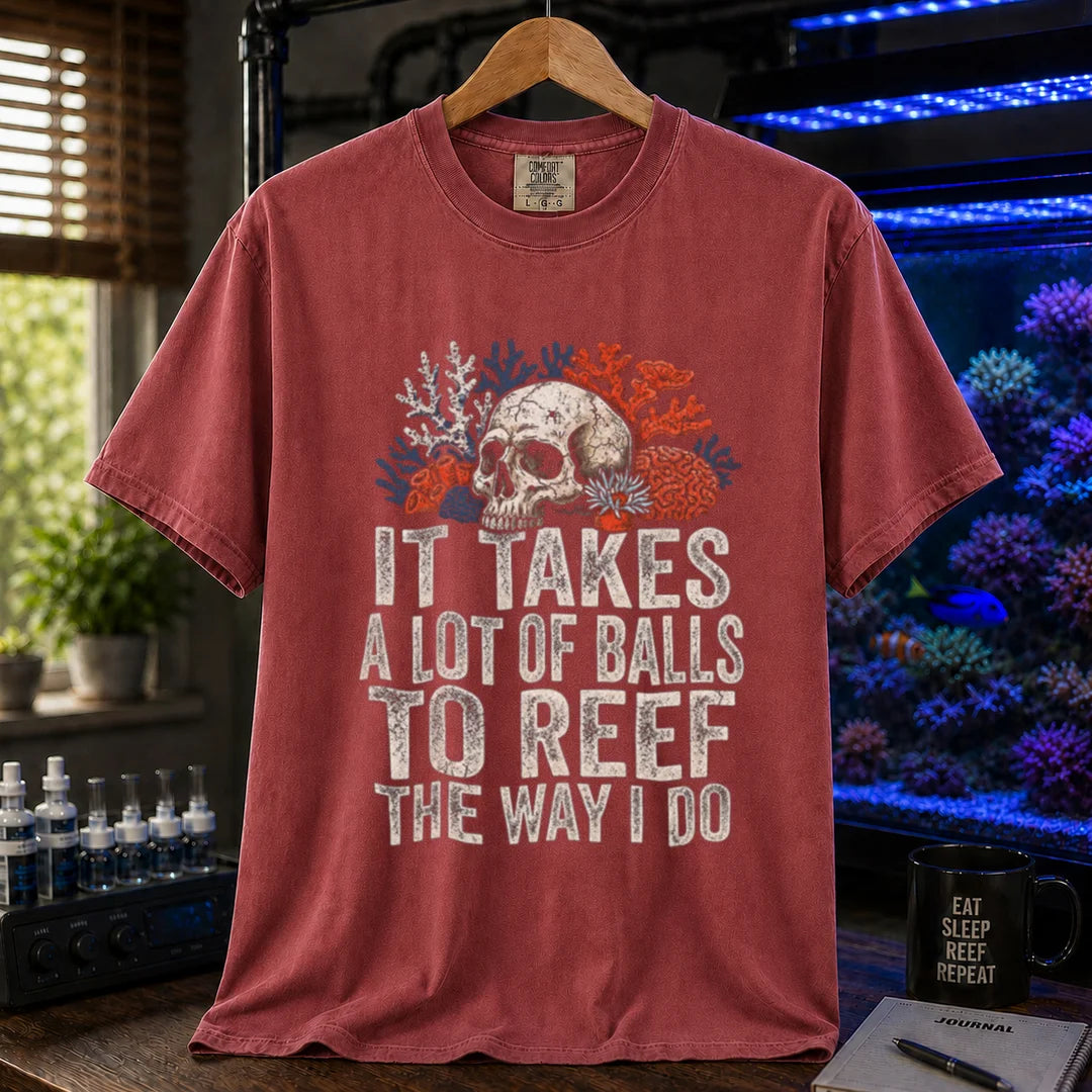 Saltwater aquarium graphic t-shirt featuring distressed white typography reading It Takes A Lot Of Balls To Reef The Way I Do with an illustration of a skull and coral formations, maroon, red crew neck tee