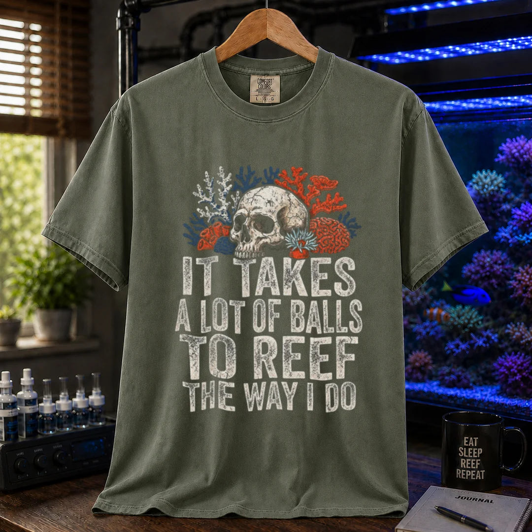 Saltwater aquarium graphic t-shirt featuring distressed white typography reading It Takes A Lot Of Balls To Reef The Way I Do with an illustration of a skull and coral formations, military green crew neck tee