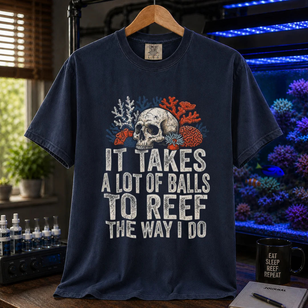 Saltwater aquarium graphic t-shirt featuring distressed white typography reading It Takes A Lot Of Balls To Reef The Way I Do with an illustration of a skull and coral formations, navy crew neck tee