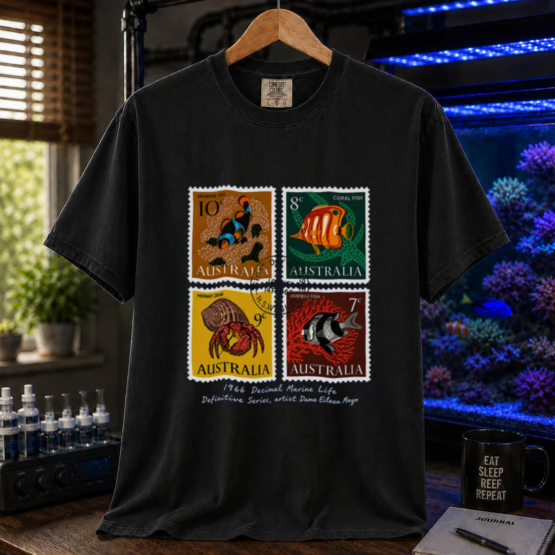 Saltwater aquarium graphic t-shirt featuring a vintage block of four 1966 Australian marine life stamps designed by Dame Eileen Mayo with postmark and script text, black crew neck tee