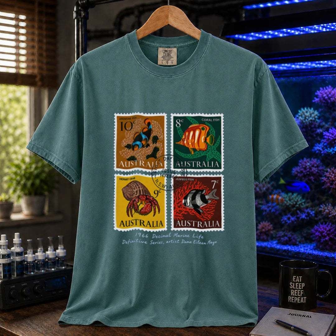 Saltwater aquarium graphic t-shirt featuring a vintage block of four 1966 Australian marine life stamps designed by Dame Eileen Mayo with postmark and script text, green crew neck tee