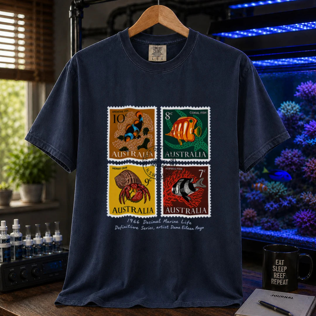 Saltwater aquarium graphic t-shirt featuring a vintage block of four 1966 Australian marine life stamps designed by Dame Eileen Mayo with postmark and script text, navy crew neck tee