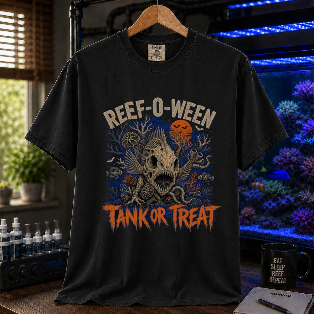 Saltwater aquarium graphic t-shirt design featuring cream arched typography reading Reef-O-Ween and dripping orange text reading Tank Or Treat with a large fish skull skeleton, full moon, bats, and spooky reef corals, black crew neck tee