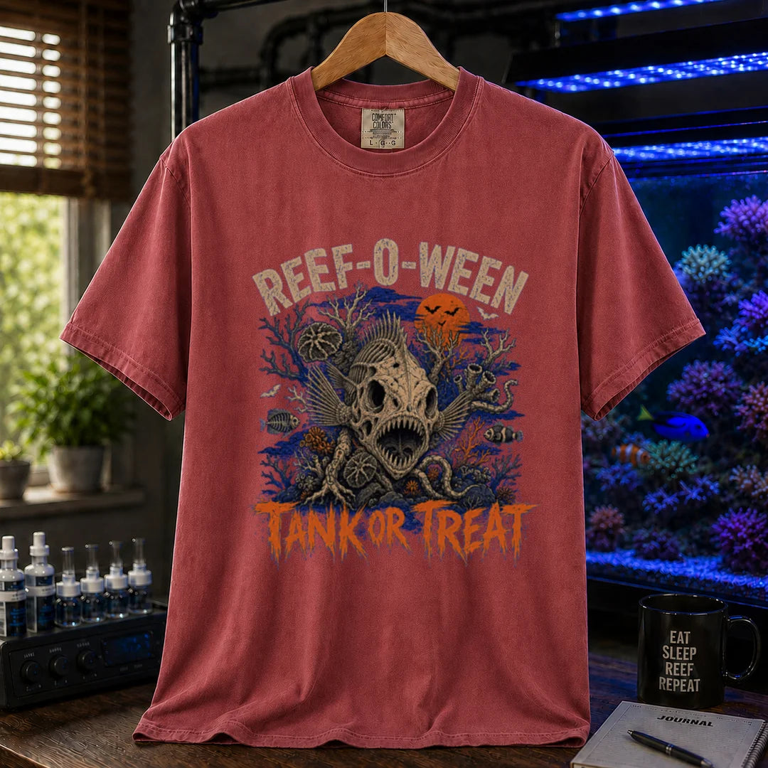 Saltwater aquarium graphic t-shirt design featuring cream arched typography reading Reef-O-Ween and dripping orange text reading Tank Or Treat with a large fish skull skeleton, full moon, bats, and spooky reef corals, maroon, red crew neck tee