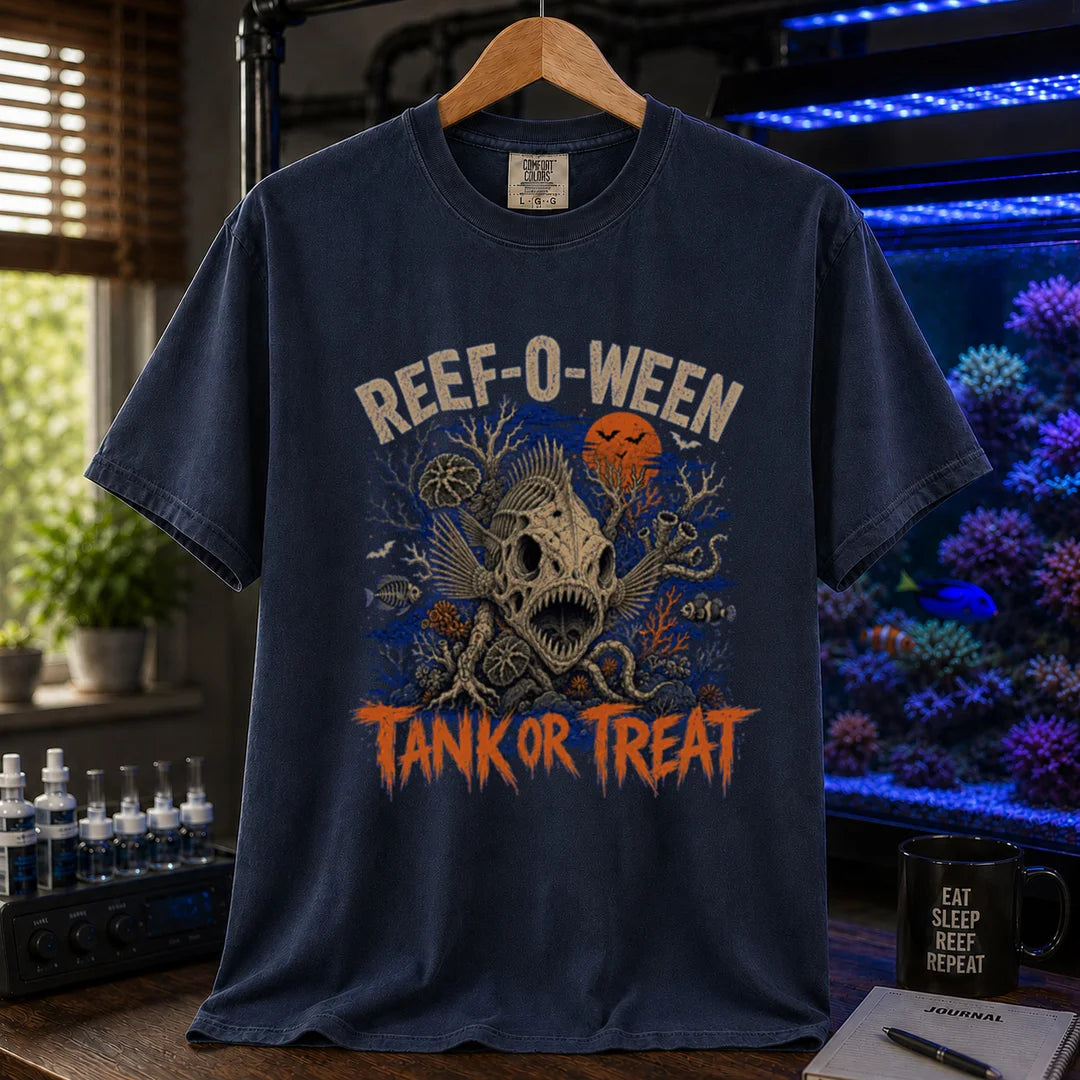 Saltwater aquarium graphic t-shirt design featuring cream arched typography reading Reef-O-Ween and dripping orange text reading Tank Or Treat with a large fish skull skeleton, full moon, bats, and spooky reef corals, navy crew neck tee