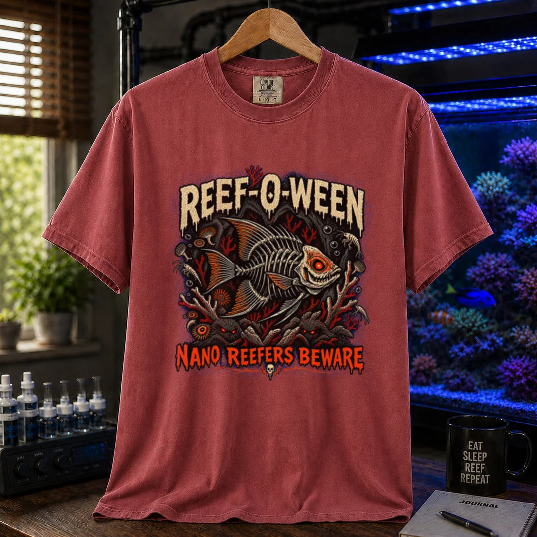 Saltwater aquarium graphic t-shirt design featuring dripping cream and orange typography reading Reef-O-Ween and Nano Reefers Beware with a glowing-eyed skeletal fish illustration and creepy corals, maroon, red crew neck tee
