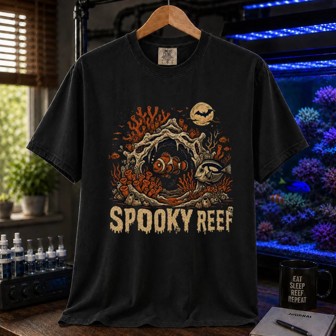 Saltwater aquarium graphic t-shirt design featuring dripping cream typography reading Spooky Reef with a spooky underwater scene featuring skeletal coral, a full moon with a bat, and eerie fish illustrations, black crew neck tee