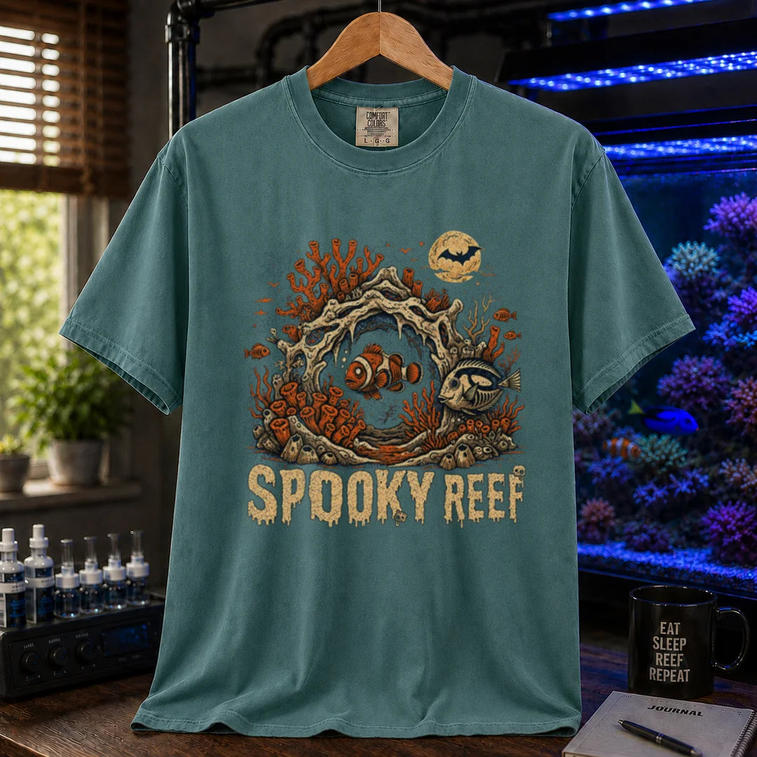 Saltwater aquarium graphic t-shirt design featuring dripping cream typography reading Spooky Reef with a spooky underwater scene featuring skeletal coral, a full moon with a bat, and eerie fish illustrations, green crew neck tee