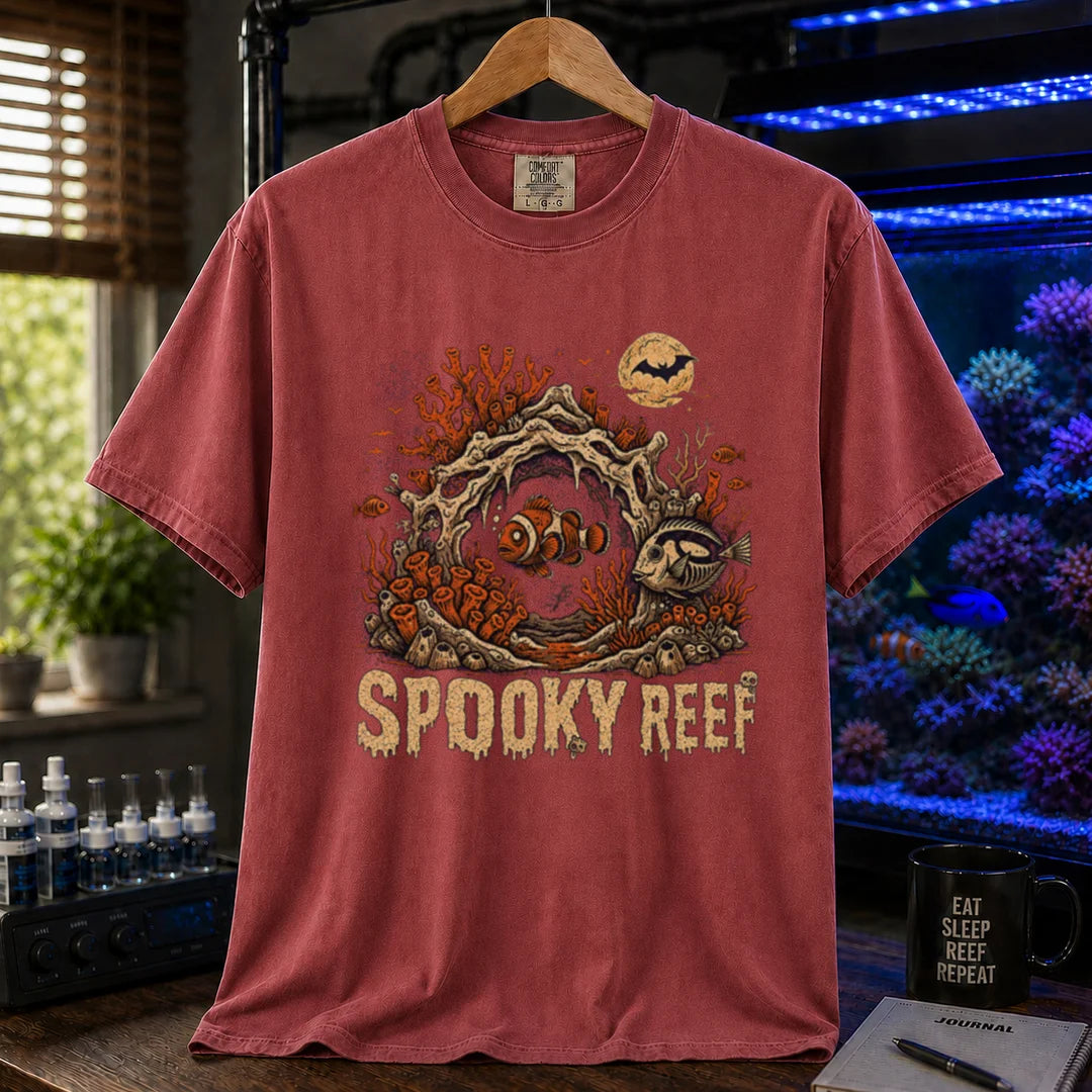 Saltwater aquarium graphic t-shirt design featuring dripping cream typography reading Spooky Reef with a spooky underwater scene featuring skeletal coral, a full moon with a bat, and eerie fish illustrations, maroon, red crew neck tee