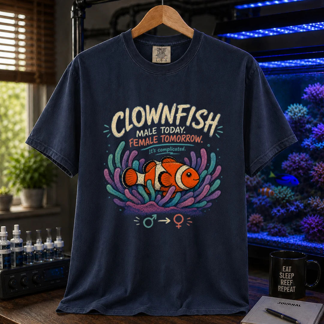 Saltwater aquarium graphic t-shirt design featuring distressed vintage typography reading Clownfish Male Today. Female Tomorrow. It's complicated with a clownfish in an anemone and gender symbols on a navy t-shirt