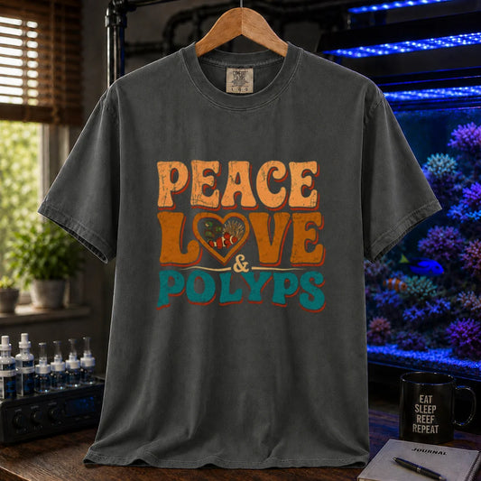 Saltwater aquarium graphic t-shirt design featuring retro distressed typography reading Peace Love & Polyps with a heart-shaped graphic enclosing a clownfish and anemone on a dark grey tee