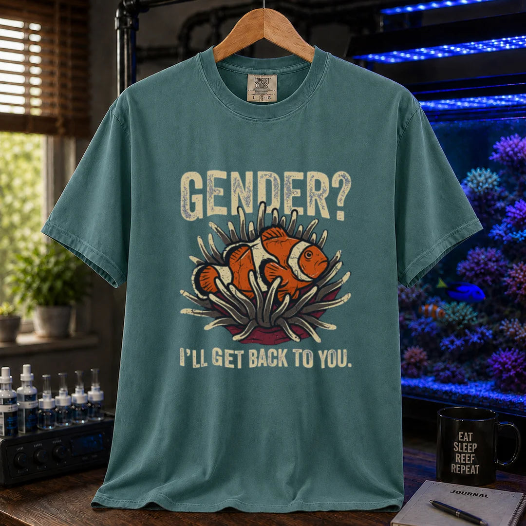 Saltwater aquarium graphic t-shirt design featuring distressed typography reading Gender? I'll Get Back To You with a central illustration of a clownfish in an anemone on a green tee
