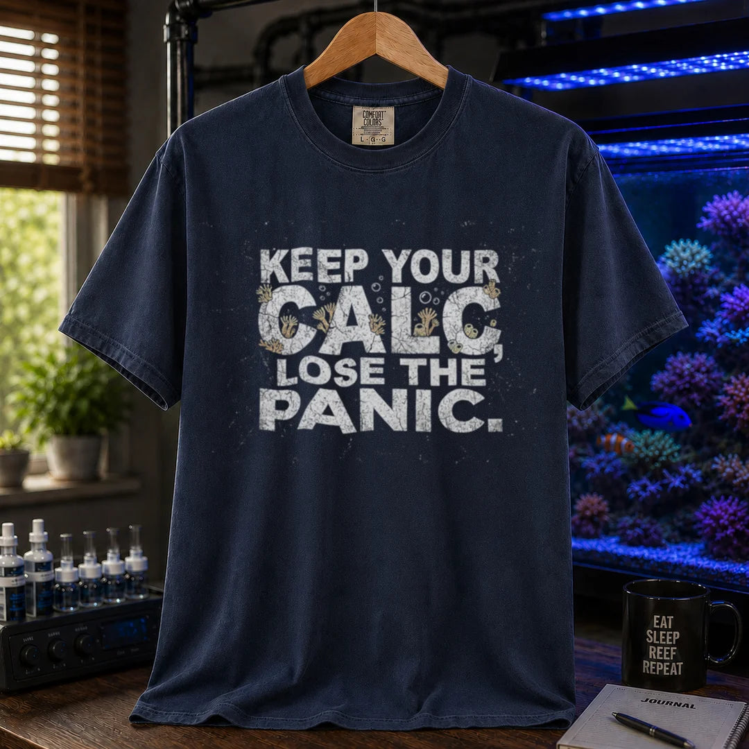 Saltwater aquarium graphic t-shirt design featuring distressed white typography reading Keep Your Calc, Lose The Panic with coral details inside the lettering on a navy tee