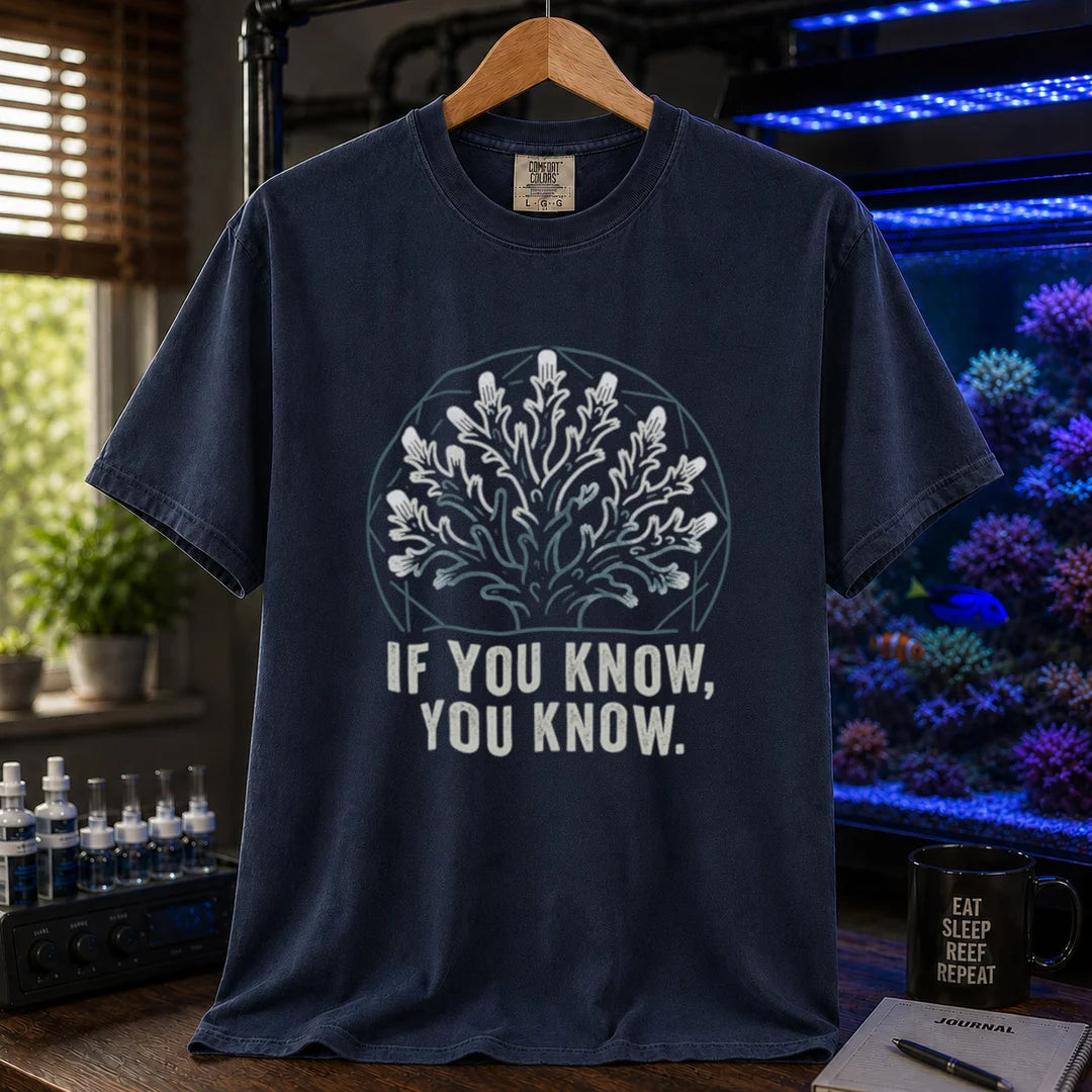 Saltwater aquarium graphic t-shirt design featuring a minimalist line-art coral colony inside a geometric frame with typography reading If You Know, You Know on a navy tee