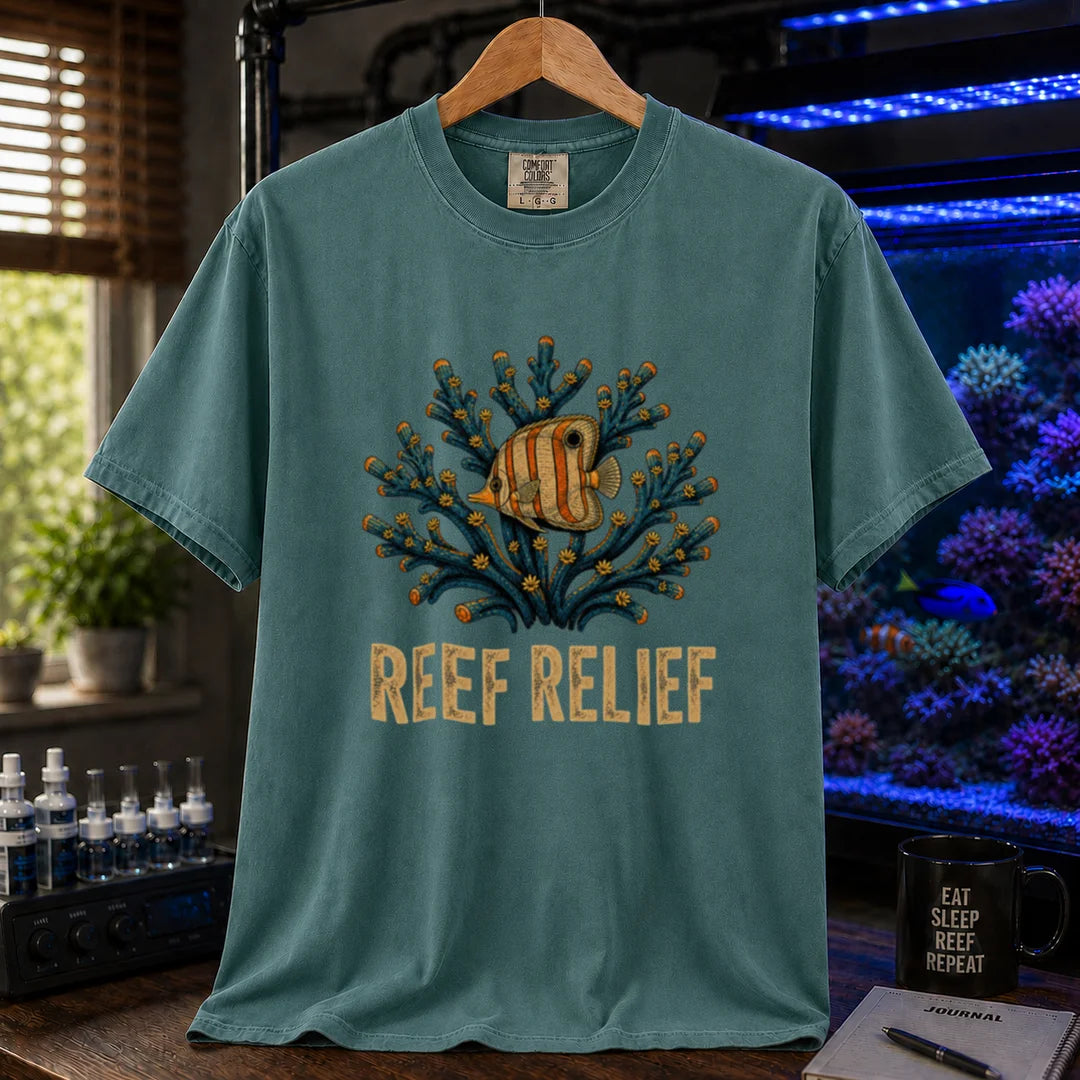Saltwater aquarium graphic t-shirt design featuring a butterflyfish nestled in a blue coral colony with distressed typography reading Reef Relief on a green tee