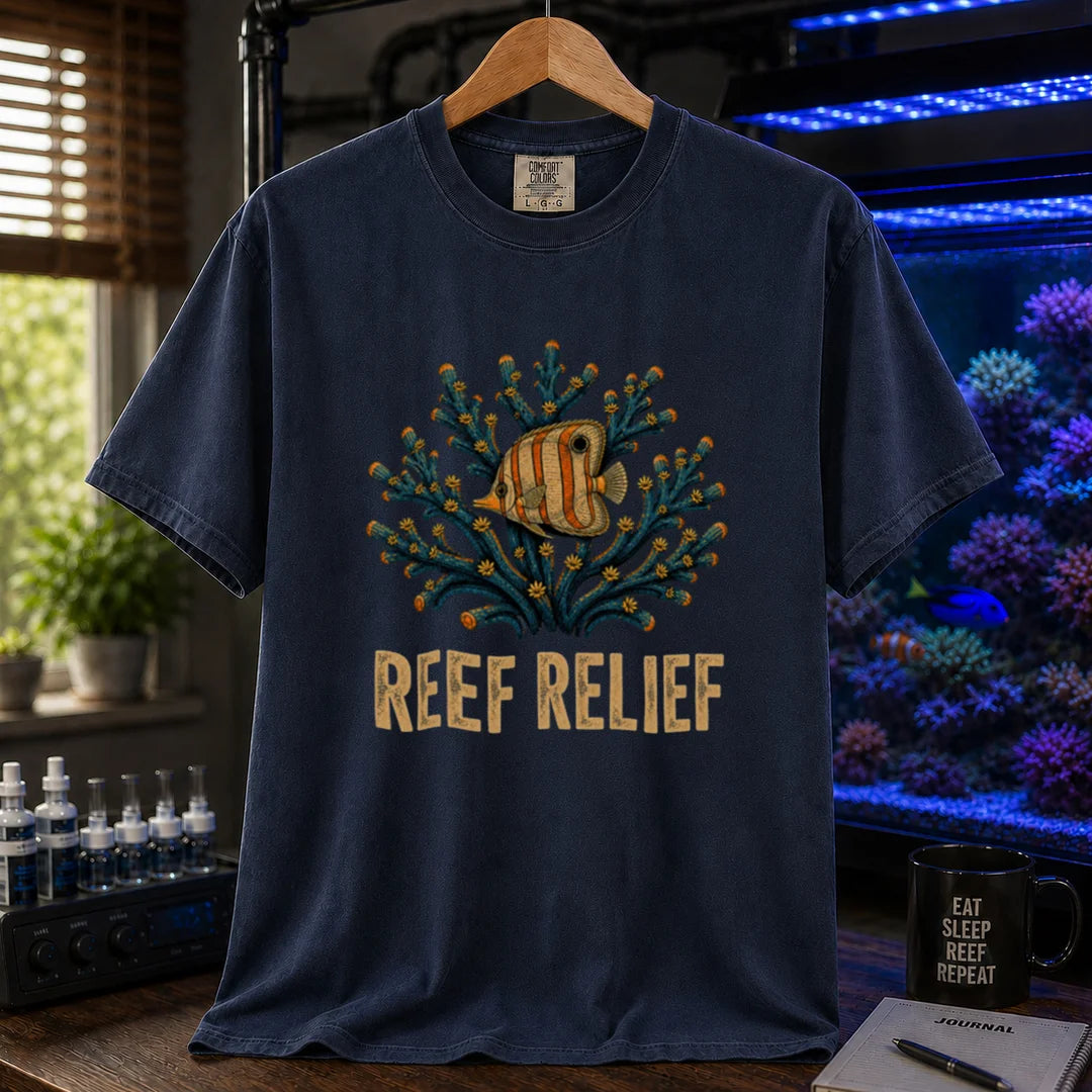 Saltwater aquarium graphic t-shirt design featuring a butterflyfish nestled in a blue coral colony with distressed typography reading Reef Relief on a navy tee