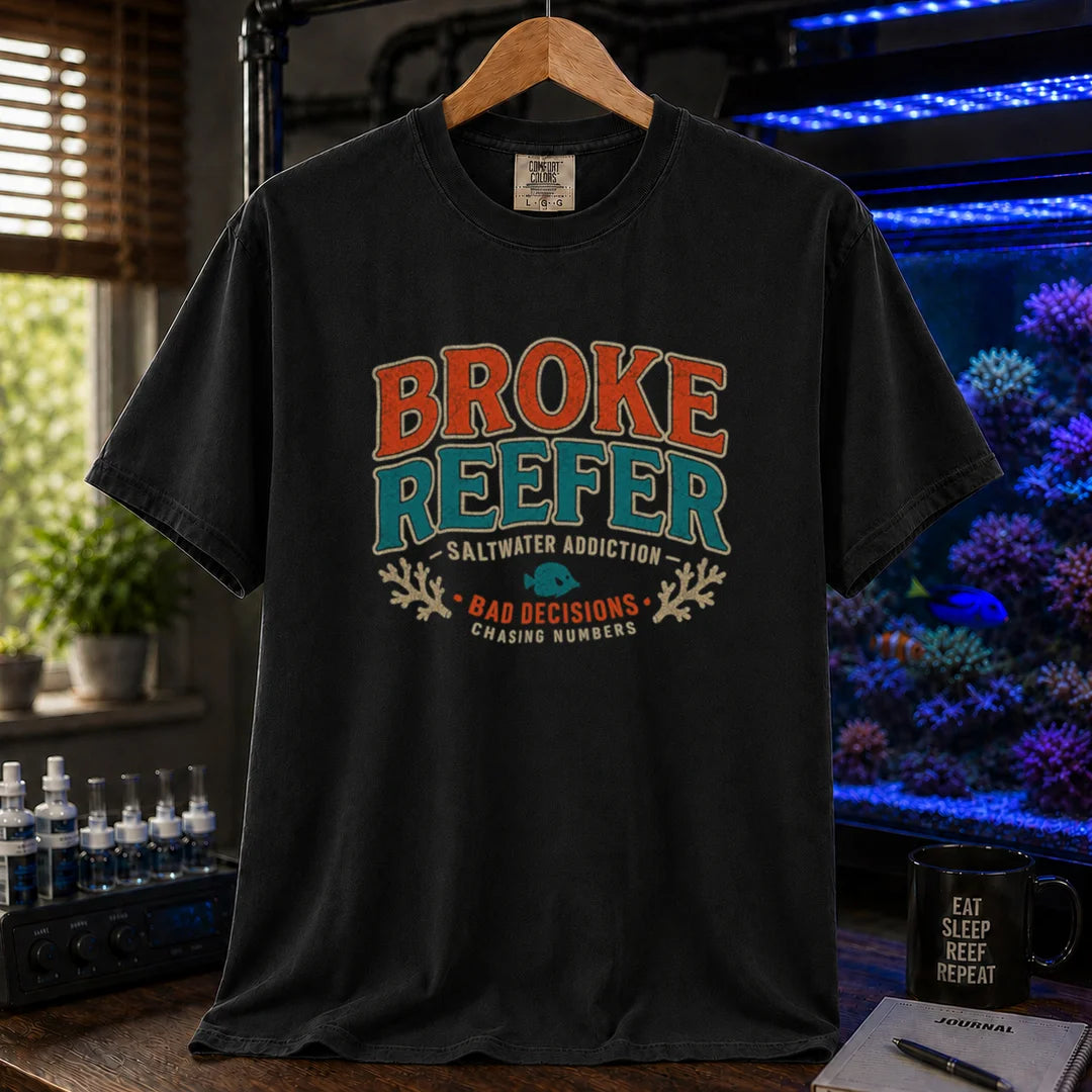 Saltwater aquarium graphic t-shirt design featuring a vintage badge reading Broke Reefer Saltwater Addiction Bad Decisions Chasing Numbers with coral and fish illustrations on a black tee