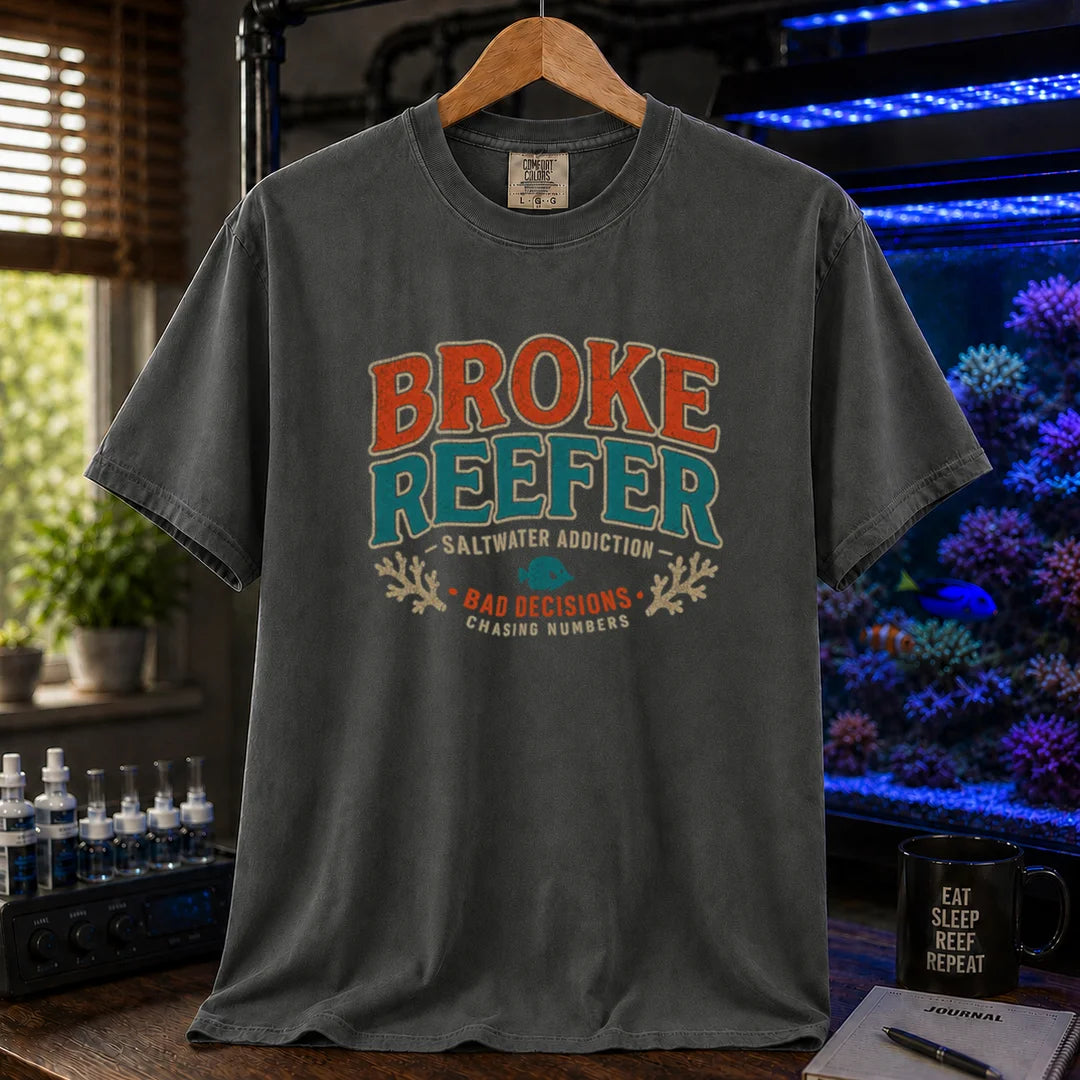 Saltwater aquarium graphic t-shirt design featuring a vintage badge reading Broke Reefer Saltwater Addiction Bad Decisions Chasing Numbers with coral and fish illustrations on a dark grey tee