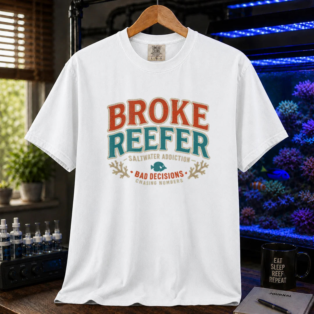 Saltwater aquarium graphic t-shirt design featuring a vintage badge reading Broke Reefer Saltwater Addiction Bad Decisions Chasing Numbers with coral and fish illustrations on a WHITE tee